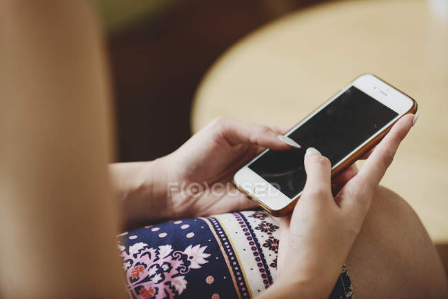 Cropped image of woman using smartphone — Stock Photo