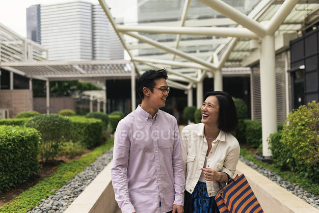 Junge lässige asiatische Paar mit Taschen beim Einkaufen in Einkaufszentrum — Stockfoto