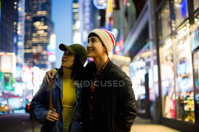 Jovem asiático casal olhando ao redor no tempo quadrado — Fotografia de Stock