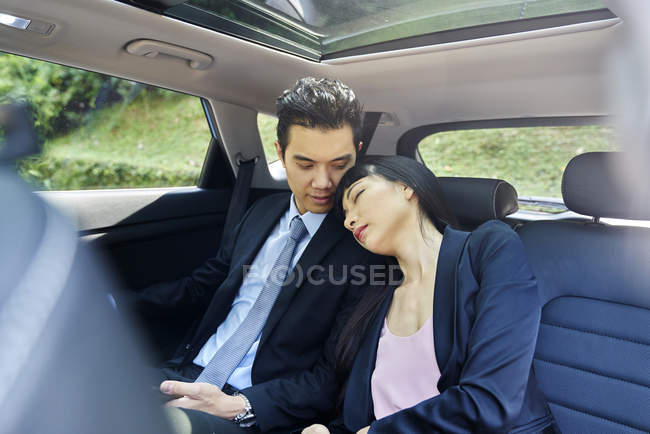 Couple resting in the back seat of a car — Stock Photo