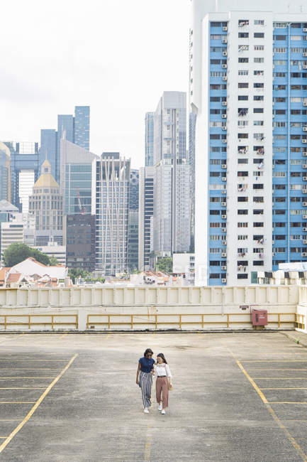 Young casual asian girls walking on roof — Stock Photo