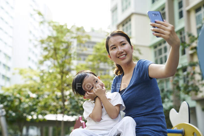 Jovem mãe tirando uma selfie com seu filho — Fotografia de Stock