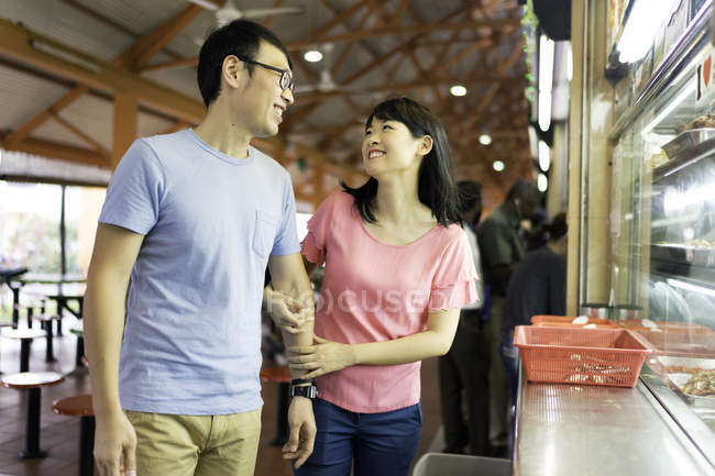 Happy asian couple walking together and holding hands — Stock Photo