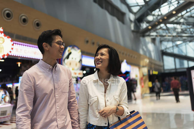 Jeune casual asiatique couple avec sacs à shopping dans le centre commercial — Photo de stock