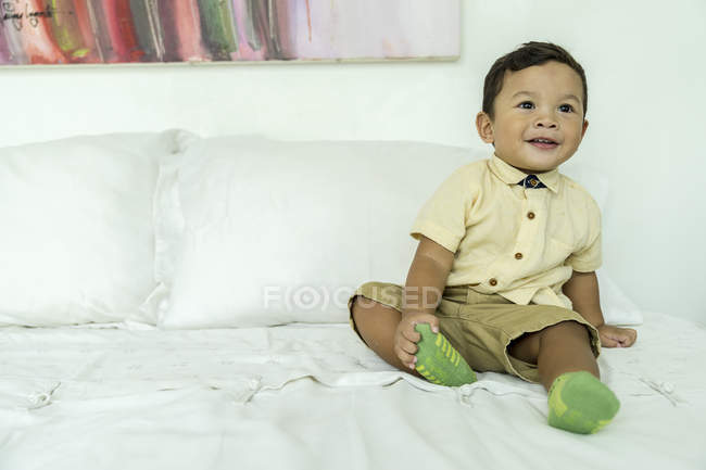 Ein Kind auf einem Bett im Haus — Stockfoto