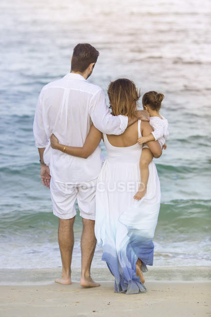 Vista posteriore di felice famiglia caucasica sulla spiaggia — Foto stock