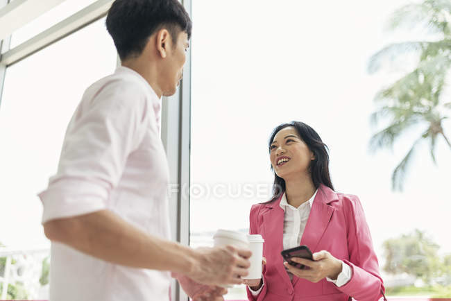 Attractive young asian couple sharing coffee together — Stock Photo