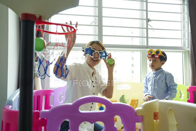 Asiático madre y hijo vinculación con divertido gafas - foto de stock
