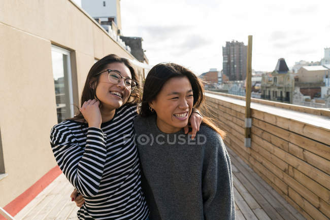 Jóvenes mujeres chinas se divierten en el balcón - foto de stock