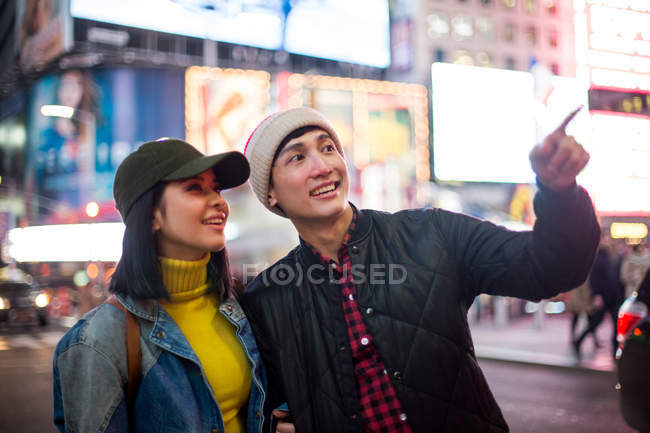 Young asian couple  looking around in time square — Stock Photo