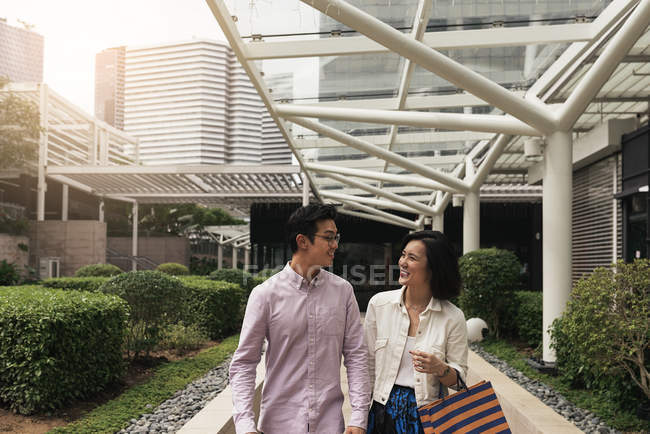 Молодая случайная азиатская пара с сумками в торговом центре — стоковое фото