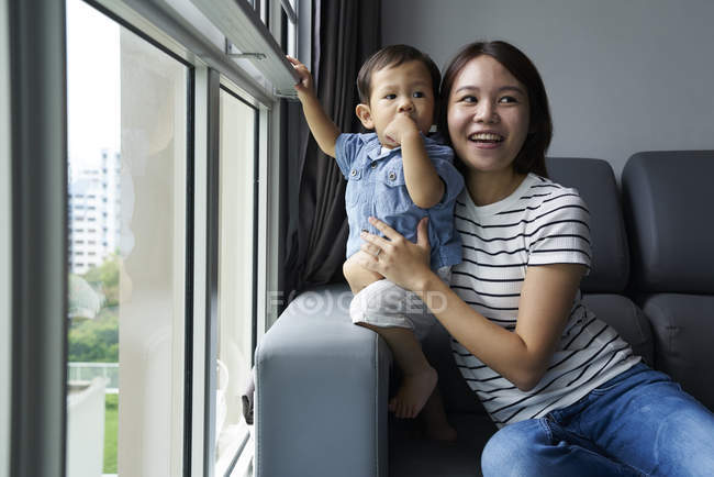 Madre jugando con su hijo en el salón - foto de stock