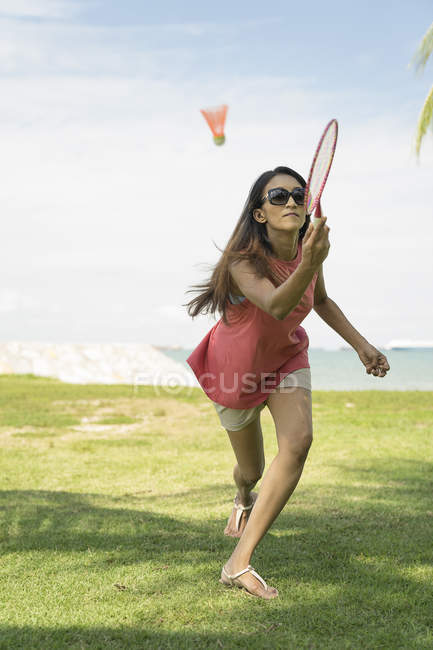 Азиатка играет в бадминтон на пляже . — стоковое фото