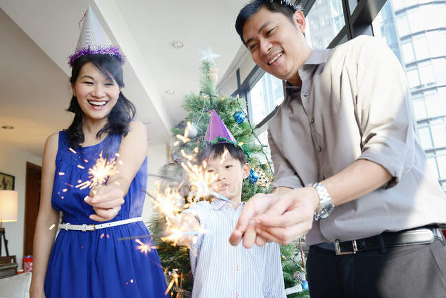 Asiatique famille célébrer Noël vacances avec feux d'artifice étincelles — Photo de stock
