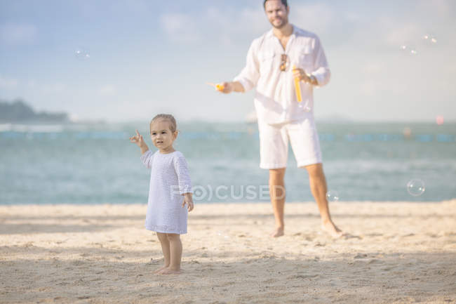 Щаслива біла сім'я на пляжі, батько з дочкою розважається — стокове фото