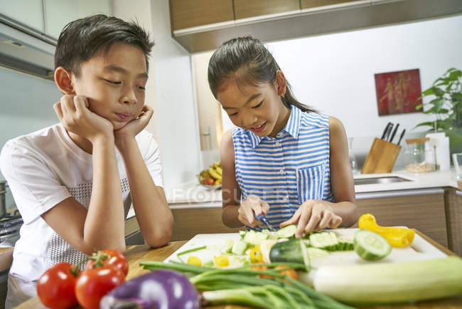 Asian brother and sister cooking together at kitchen — Stock Photo