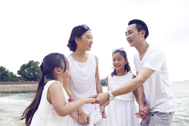 Feliz asiático familia pasando tiempo juntos en playa - foto de stock