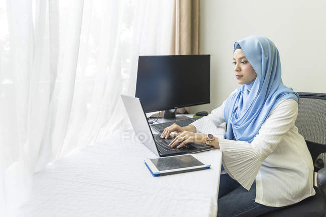 Молода мусульманка працює з дому . — стокове фото