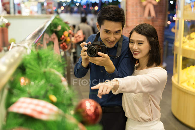 Giovane coppia asiatica alla ricerca di roba in centro commerciale — Foto stock