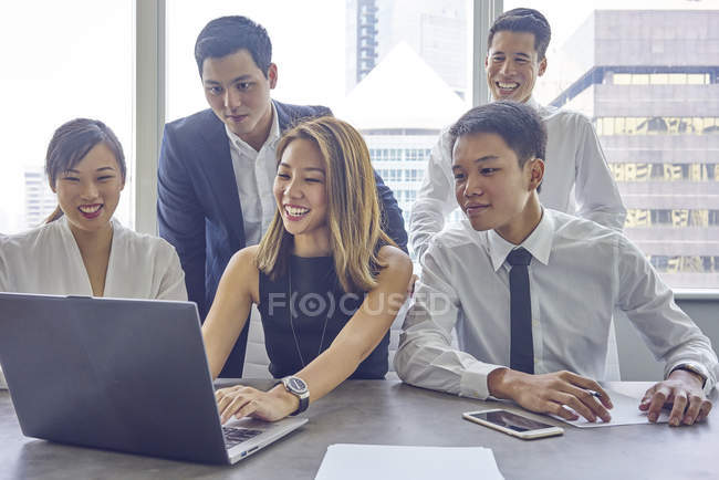 Jeunes gens d'affaires asiatiques travaillant avec ordinateur portable au bureau moderne — Photo de stock