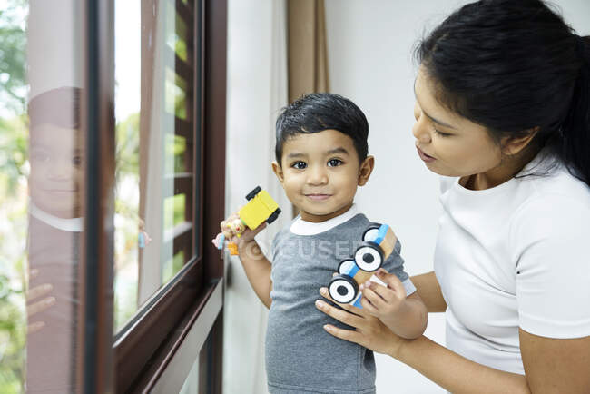 Madre interactuando con su hijo en casa - foto de stock