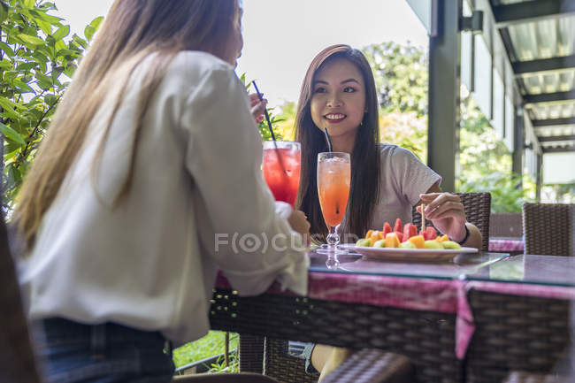 Two young ladies enjoying the fruits. — Stock Photo