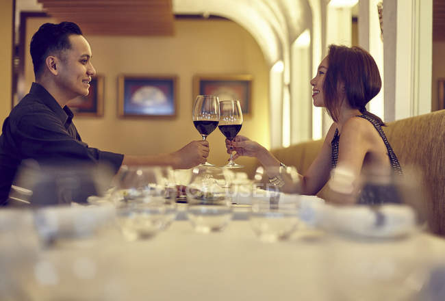 Young asian couple cherring at restaurant — Stock Photo