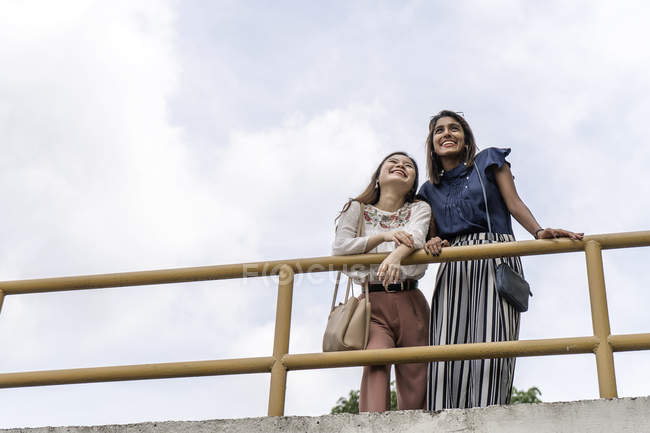 Молоді випадкові азіатські дівчата стоять біля паркану — стокове фото