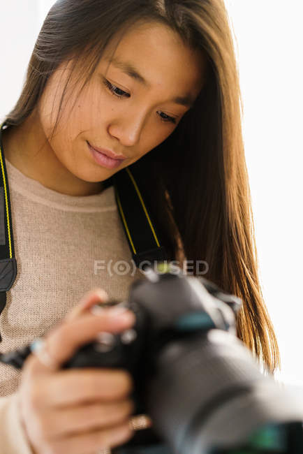 Довге волосся жінка перевіряє зображення на камеру — стокове фото