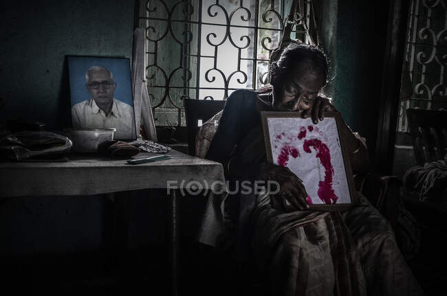 Your Soul Always With Me.... A printed copy of her Husband Feet in her Hand ,which take after her Husband Death.she will live with this Symbol. A Photo frame of her husband on to the Table — Stock Photo