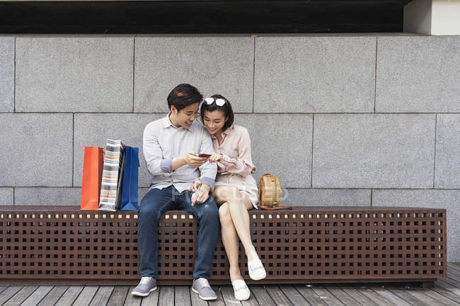 Jovem asiático casal compartilhamento smartphone juntos — Fotografia de Stock