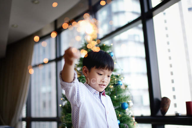 Азиатская семья празднует Рождество, мальчик с фейерверком искры — стоковое фото