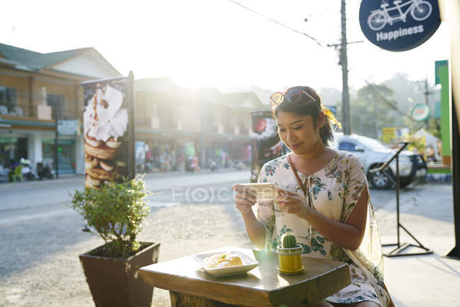 Молодая женщина фотографирует свою еду в кафе на Ко Чанг, Таиланд — стоковое фото
