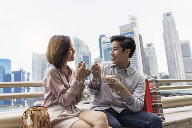 Joven asiático pareja comer comida en Singapur - foto de stock