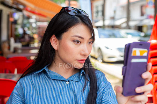 Atractivo adulto asiático mujer usando smartphone - foto de stock