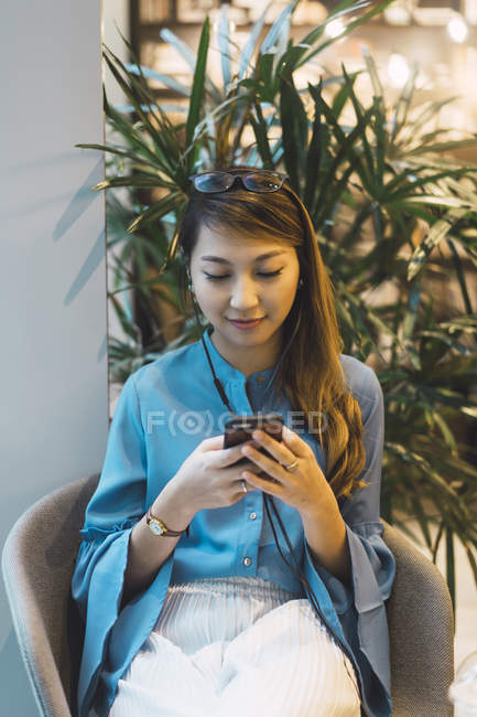 Привлекательная молодая азиатская девушка с помощью смартфона — стоковое фото