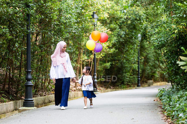 Madre e hijo paseando tranquilamente por el parque . - foto de stock