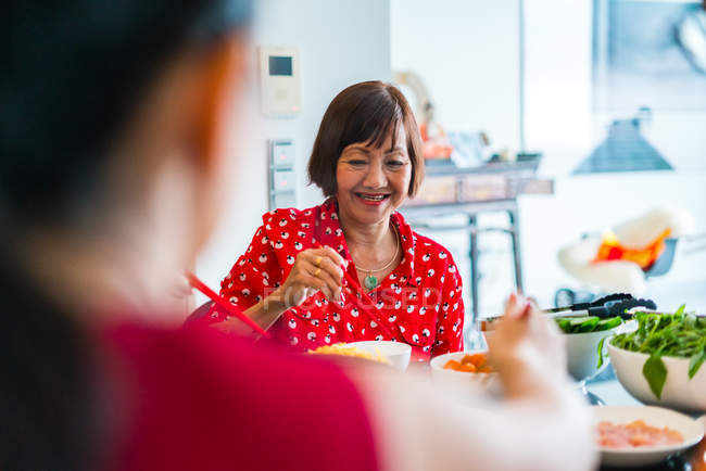 Alte asiatische Frau speist am Tisch — Stockfoto