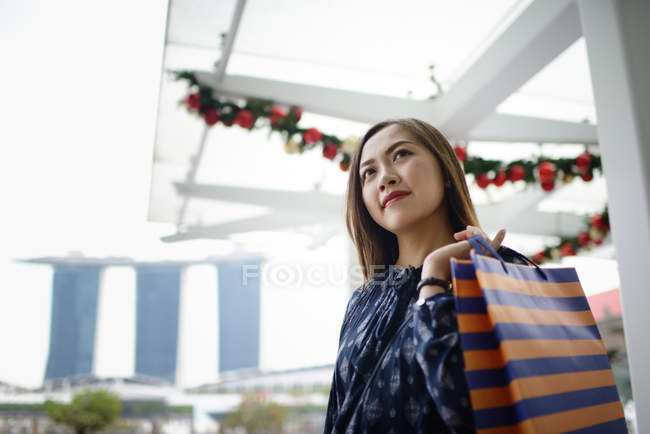 Felice bella donna asiatica a fare shopping con shopping bag — Foto stock
