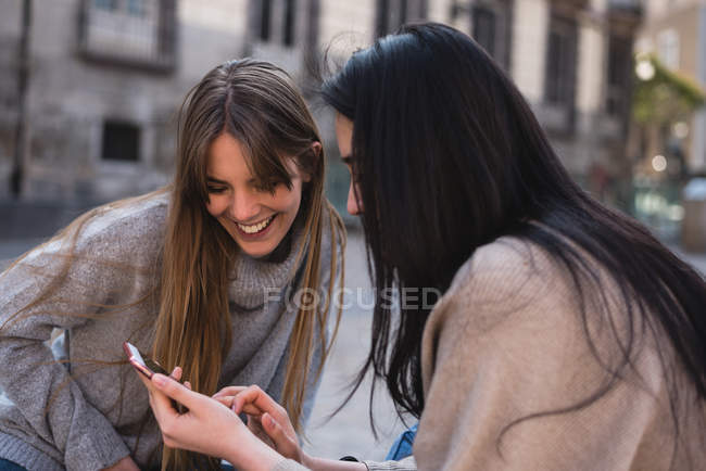 Amigos mirando su smartphone en las calles de Madrid - foto de stock