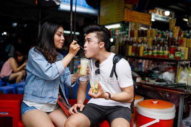 Young couple having dessert at a local food stall in Ho Chi Minh City, Vietnam. — Stock Photo
