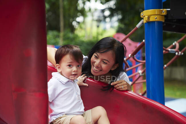 Madre e hijo en un parque infantil en Singapur - foto de stock