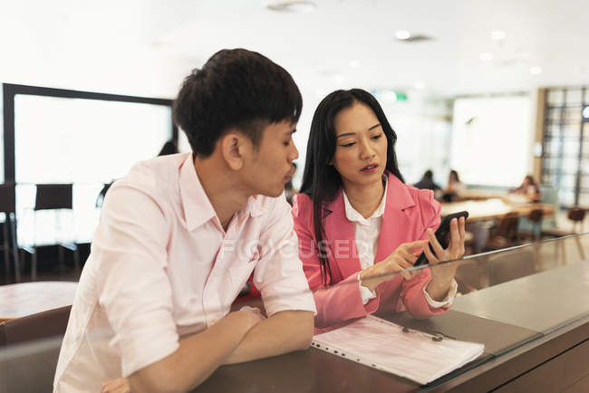 Atraente jovem asiático casal compartilhamento smartphone juntos — Fotografia de Stock