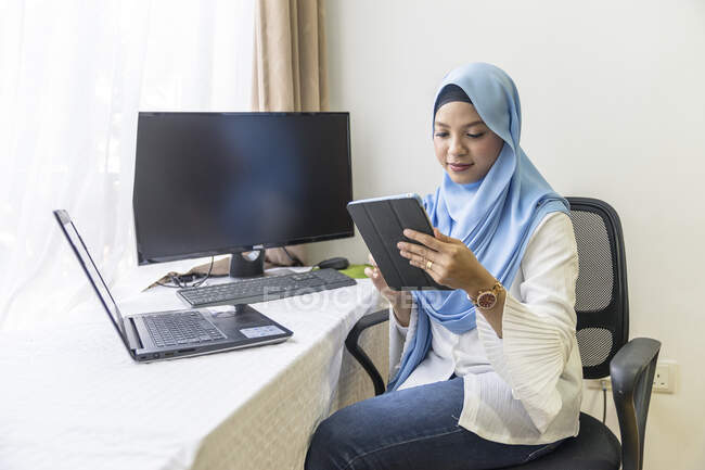 Una giovane donna musulmana che lavora da casa . — Foto stock