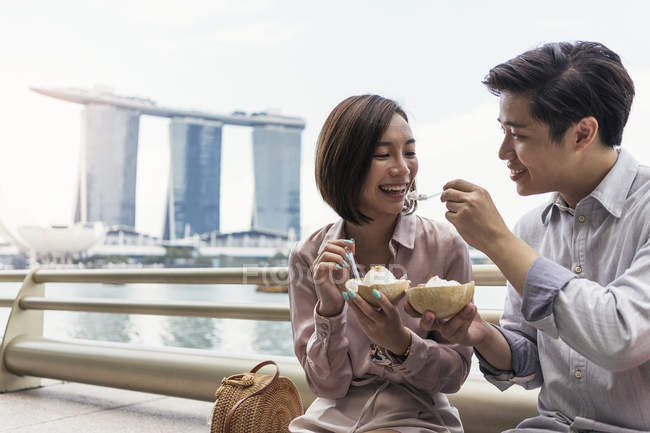 Young asian couple sharing ice cream together in Singapore — Stock Photo
