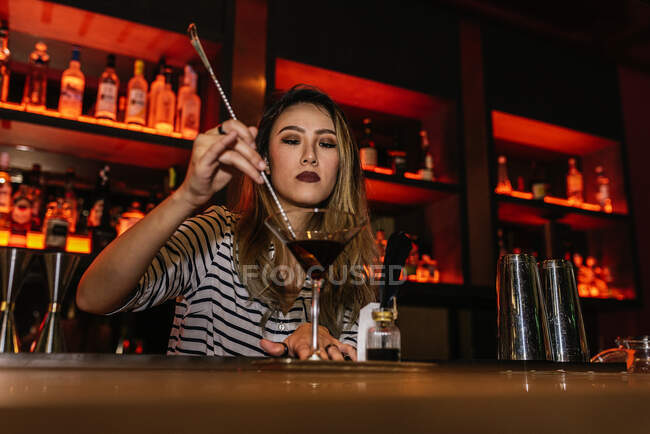 Ritratto di giovane barman donna che fa cocktail nel bar — Foto stock