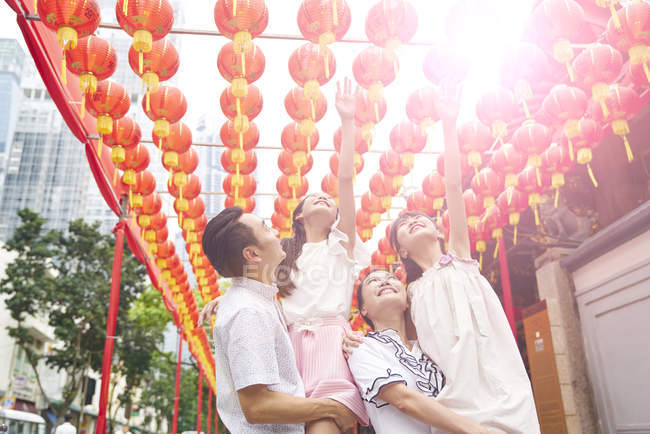 Молодая счастливая азиатская семья в традиционном буддийском храме — стоковое фото