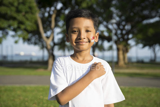 Дитина бере заставу Сінгапуру. — стокове фото