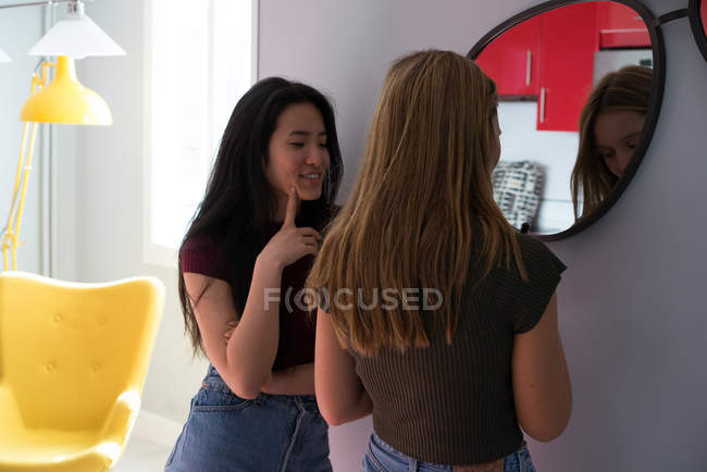 Woman doing makeup while talking to her Chinese friend. — Stock Photo