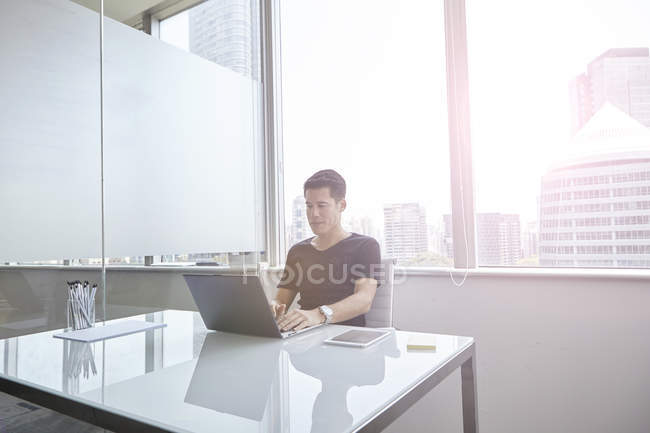 Handsome asian businessman working with laptop at home — Stock Photo